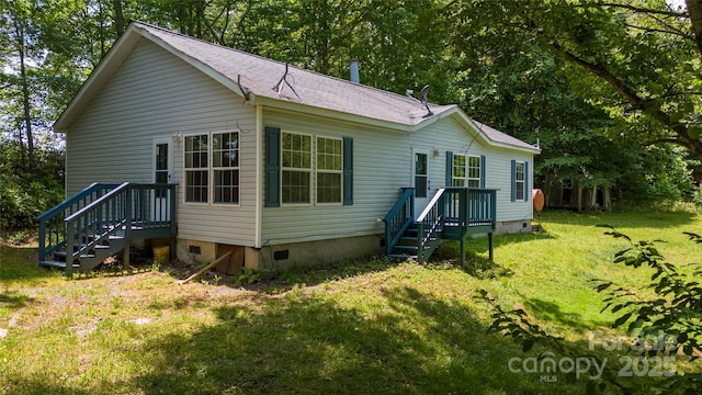 rear view of house featuring a yard