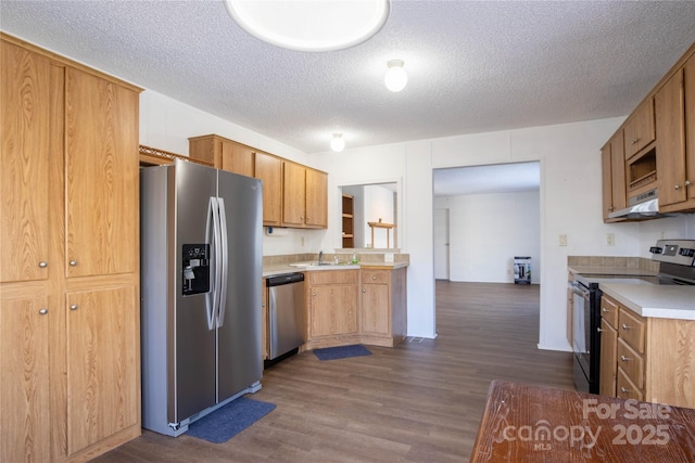 kitchen featuring a textured ceiling, stainless steel appliances, and dark wood-type flooring