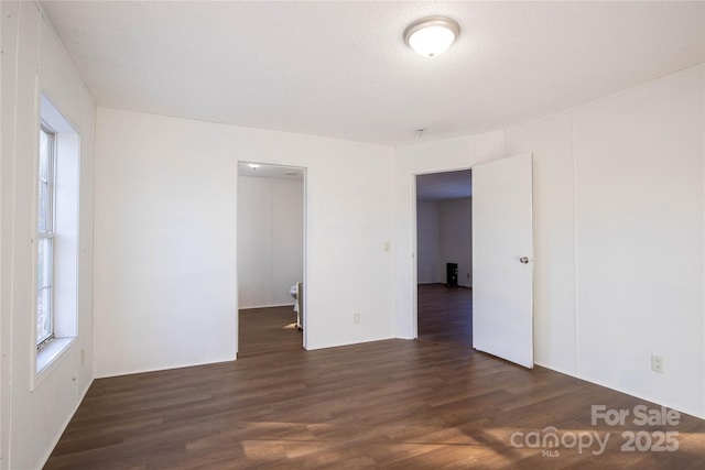 spare room with dark hardwood / wood-style flooring and a textured ceiling