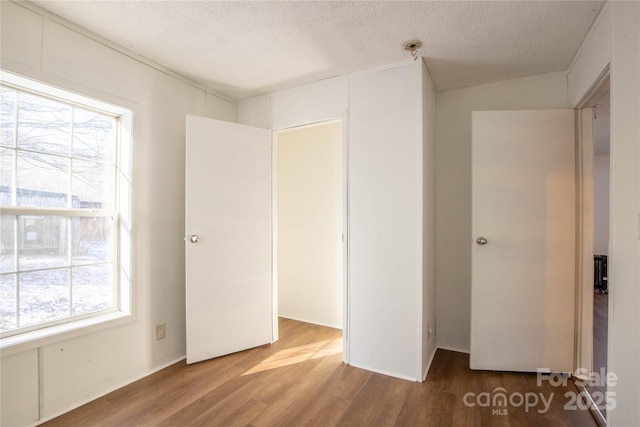 unfurnished bedroom with hardwood / wood-style floors and a textured ceiling