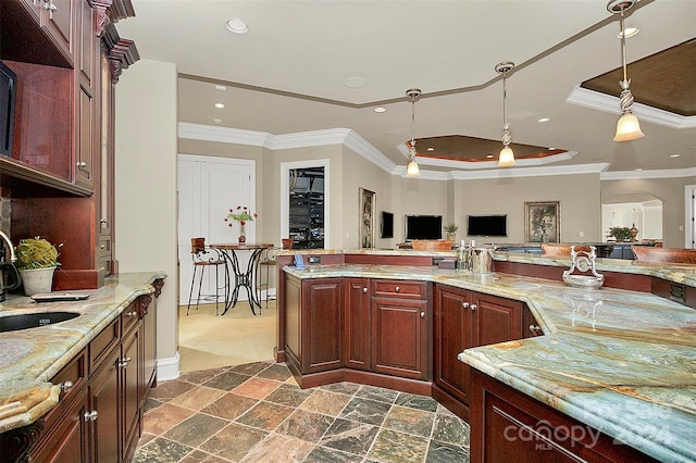 kitchen featuring decorative light fixtures, a tray ceiling, dark tile floors, sink, and ornamental molding