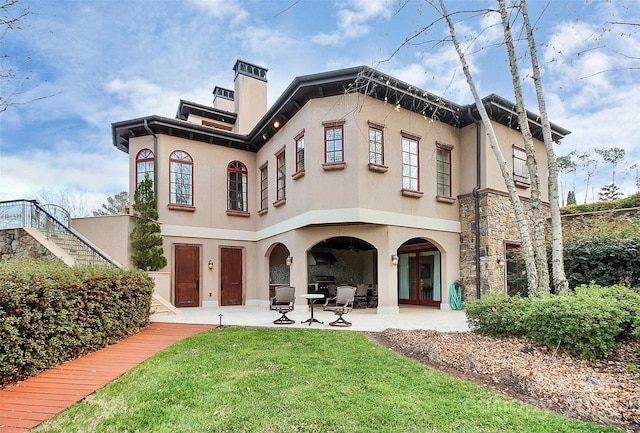 back of house with a patio, french doors, and a lawn