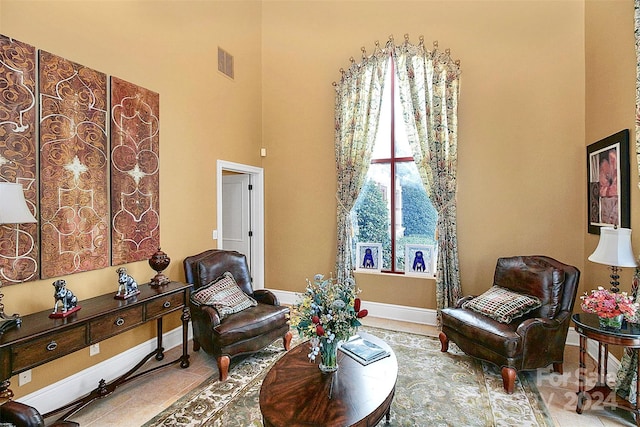 living room with light tile floors and a towering ceiling