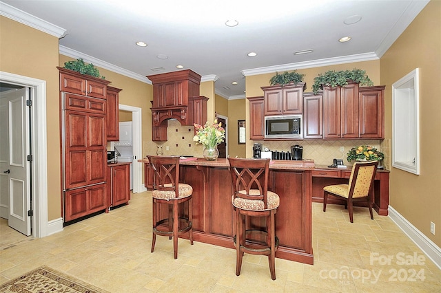 kitchen with backsplash, a kitchen breakfast bar, stainless steel microwave, and light tile floors