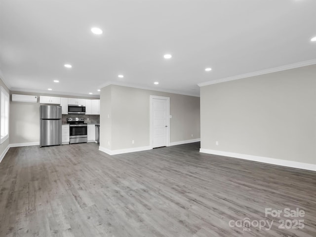 unfurnished living room featuring a wall mounted air conditioner, ornamental molding, and light hardwood / wood-style flooring