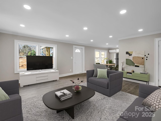 living room featuring crown molding, a healthy amount of sunlight, and light hardwood / wood-style floors