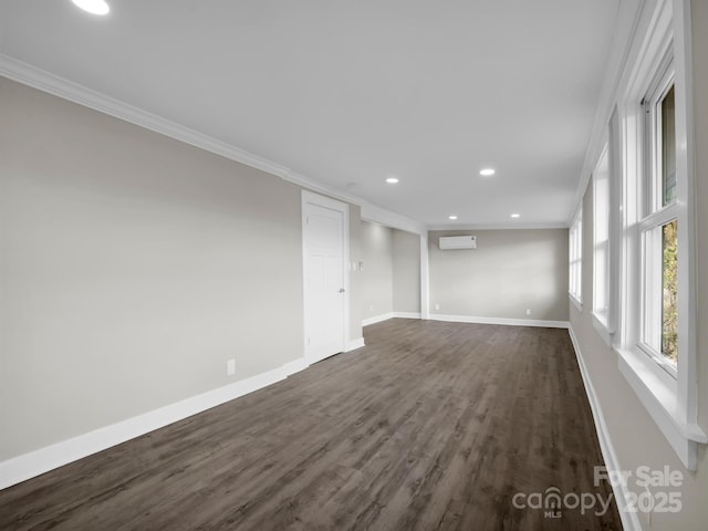 unfurnished room featuring a wall mounted AC, dark hardwood / wood-style flooring, and crown molding