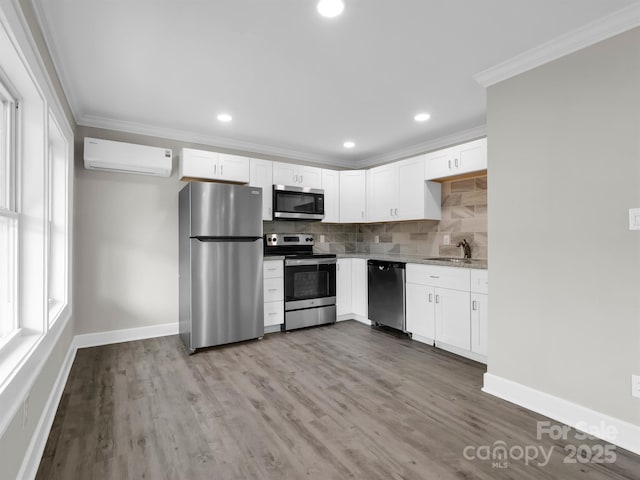 kitchen featuring white cabinets, appliances with stainless steel finishes, decorative backsplash, ornamental molding, and a wall mounted AC