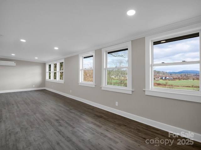 unfurnished room with an AC wall unit, dark hardwood / wood-style floors, crown molding, and a mountain view