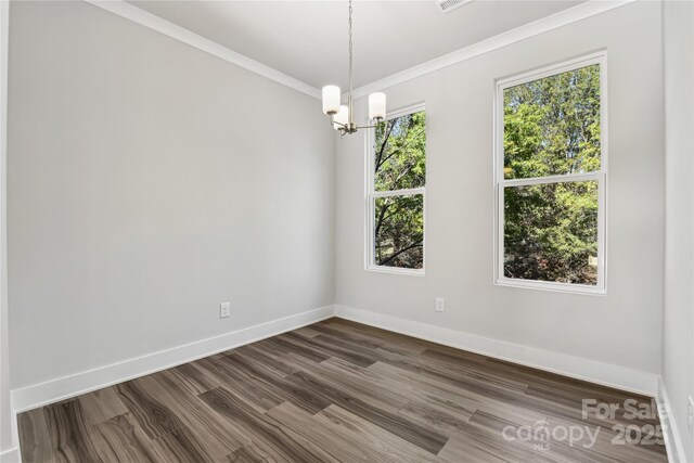 1428 Hamilton St Unit 13, Charlotte, NC 28206 - spare room with crown molding, baseboards, dark wood-style flooring, and a chandelier