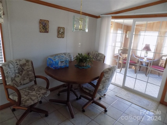 dining room featuring a notable chandelier, tile flooring, ornamental molding, and lofted ceiling