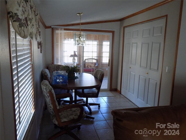 dining space with vaulted ceiling, tile flooring, ornamental molding, and an inviting chandelier