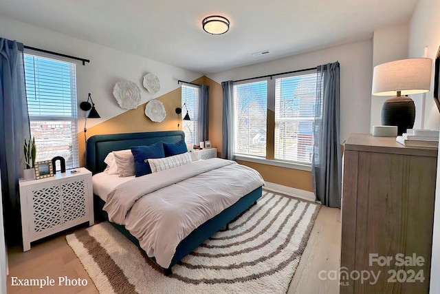 bedroom featuring multiple windows and light hardwood / wood-style floors