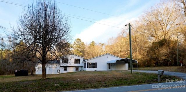 view of front of property with a front yard and a carport