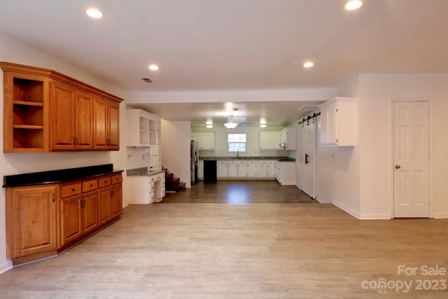 kitchen with stainless steel refrigerator, sink, and light wood-type flooring