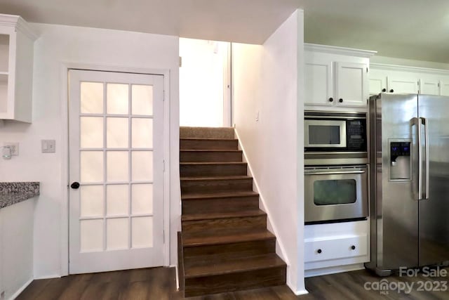 kitchen featuring stainless steel appliances, dark wood-type flooring, and white cabinets