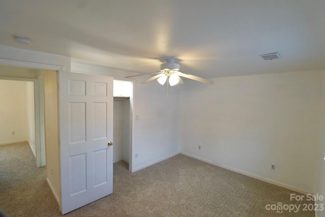 unfurnished bedroom with a closet, light carpet, and ceiling fan