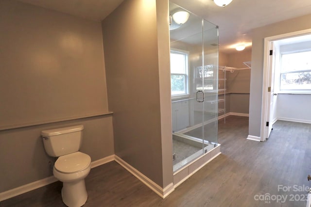 bathroom featuring a shower with door, toilet, and hardwood / wood-style flooring