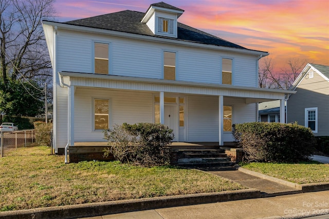 view of front of property featuring a yard and covered porch