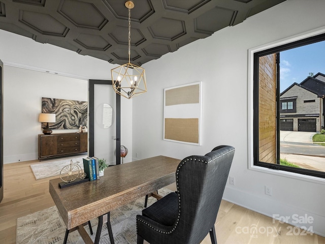 dining area with a healthy amount of sunlight, light wood-type flooring, a notable chandelier, and coffered ceiling