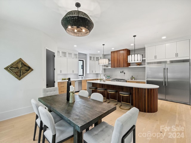 dining area with sink and light hardwood / wood-style flooring