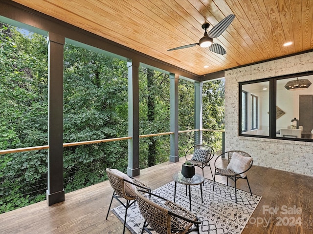 sunroom / solarium featuring ceiling fan and wood ceiling