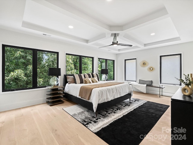 bedroom featuring beam ceiling, light hardwood / wood-style flooring, coffered ceiling, and ceiling fan