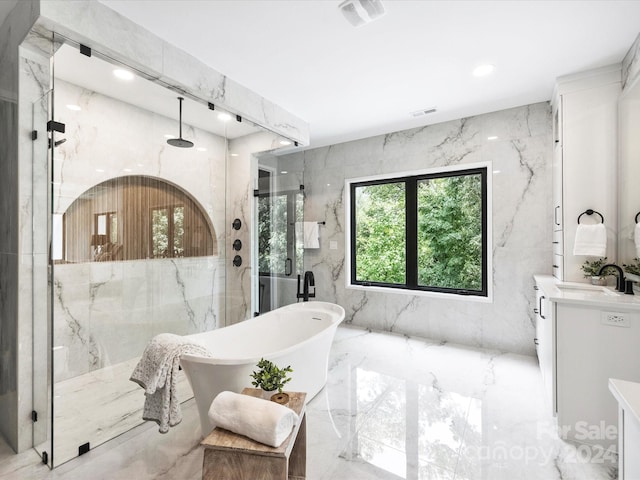 bathroom with shower with separate bathtub, vanity, tile walls, and tile patterned floors