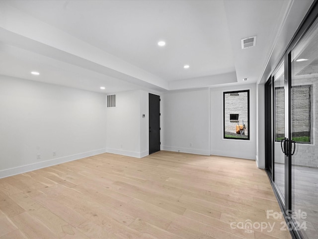 interior space featuring light hardwood / wood-style floors and a tray ceiling