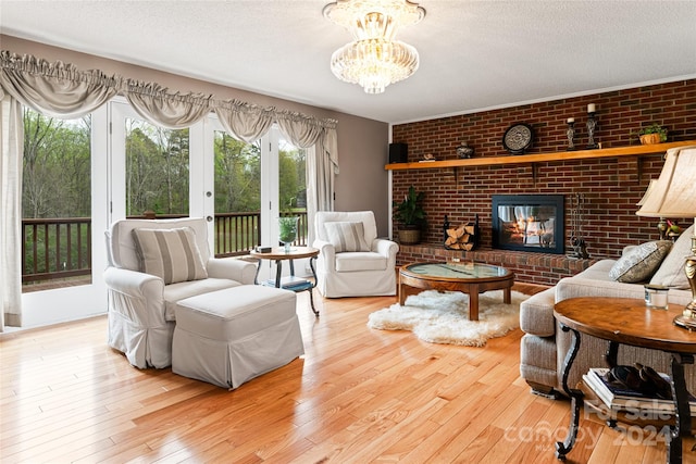 living room with a brick fireplace, a healthy amount of sunlight, brick wall, and light hardwood / wood-style floors