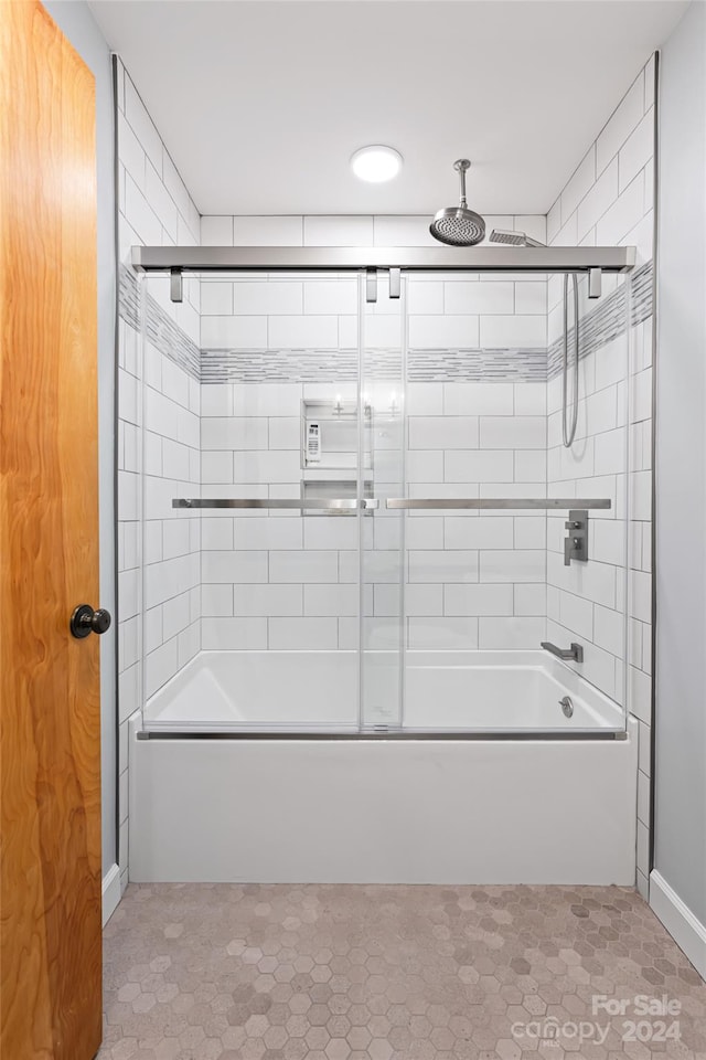 bathroom featuring tile patterned flooring and combined bath / shower with glass door