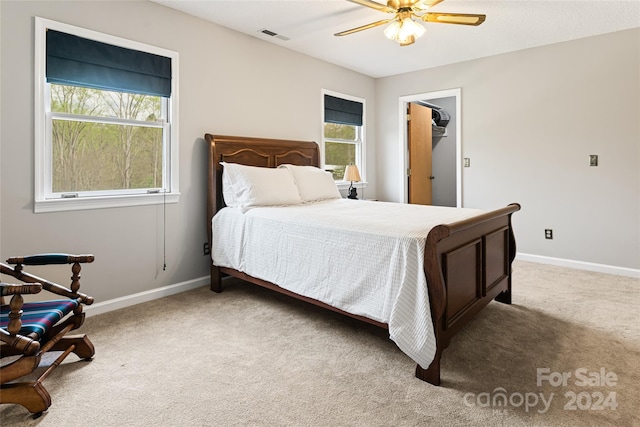 carpeted bedroom with multiple windows and ceiling fan