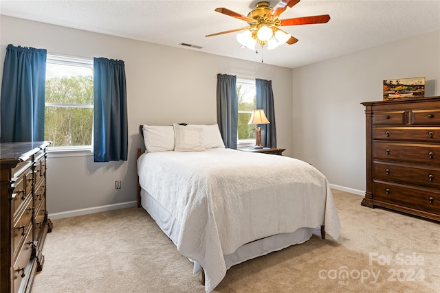 carpeted bedroom featuring a textured ceiling and ceiling fan