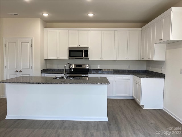 kitchen with stainless steel appliances, a kitchen island with sink, white cabinets, and sink