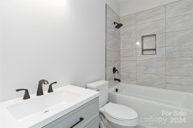 full bathroom featuring toilet, vanity, and tiled shower / bath