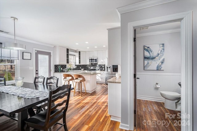 dining space featuring ornamental molding and hardwood / wood-style floors