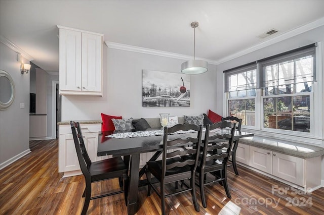 dining room with crown molding and dark hardwood / wood-style flooring