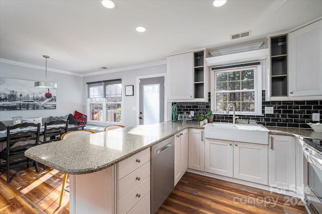 kitchen featuring white cabinetry, hanging light fixtures, sink, kitchen peninsula, and stainless steel appliances