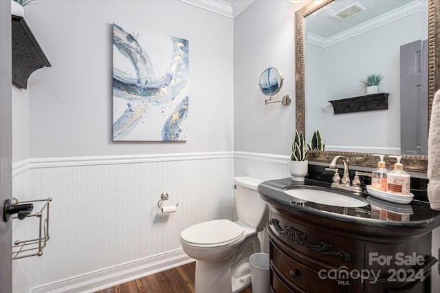 bathroom with crown molding, hardwood / wood-style floors, toilet, and vanity