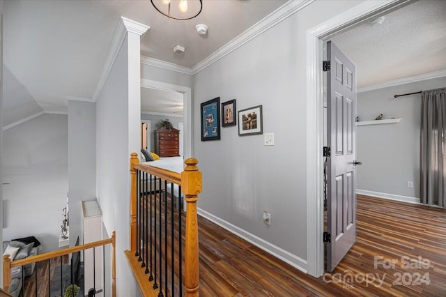 corridor with a textured ceiling, lofted ceiling, dark hardwood / wood-style flooring, and ornamental molding