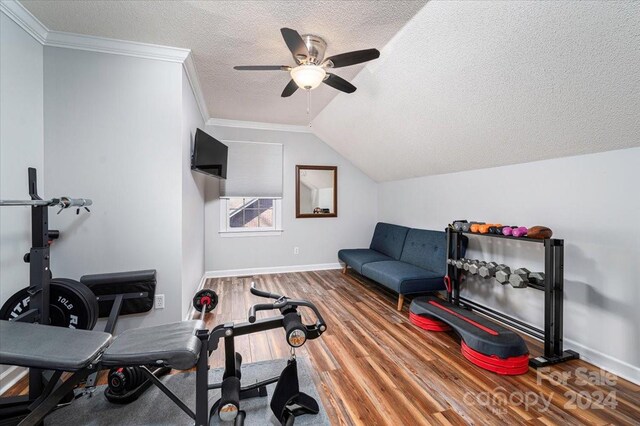 exercise room featuring wood-type flooring, crown molding, ceiling fan, a textured ceiling, and lofted ceiling