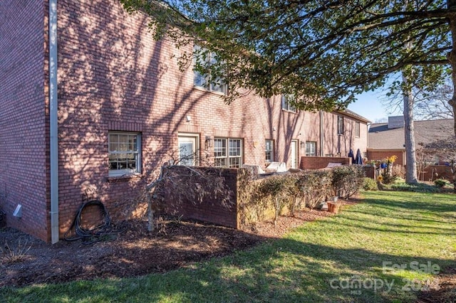 view of side of home with a yard