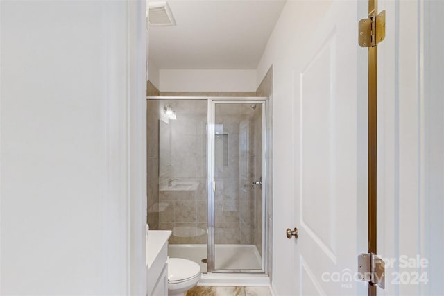 bathroom featuring walk in shower, vanity, and toilet