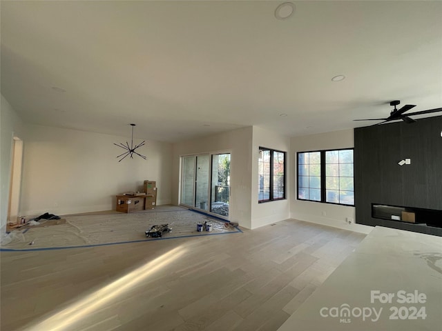 unfurnished living room with ceiling fan and light wood-type flooring