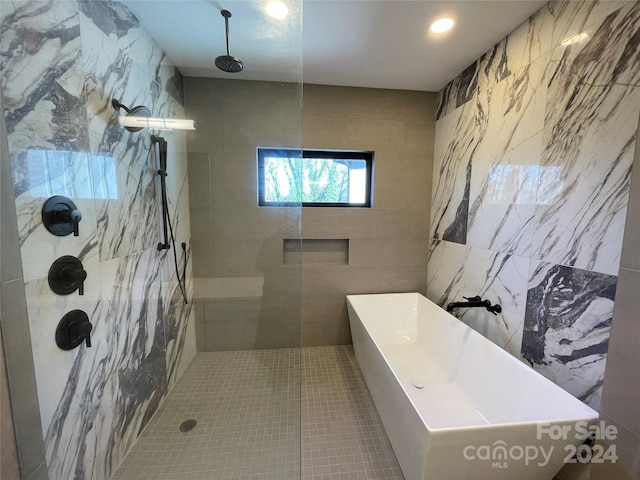 bathroom featuring tile patterned flooring, a tile shower, and tile walls