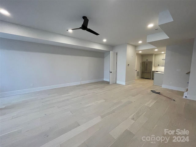 basement featuring stainless steel fridge, light hardwood / wood-style flooring, and ceiling fan