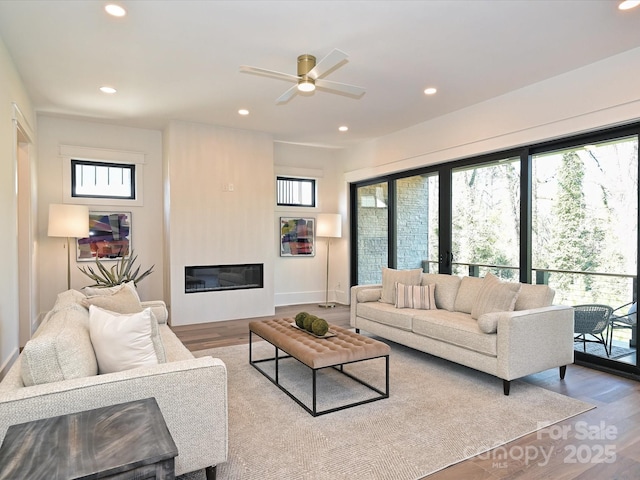 living room with light hardwood / wood-style floors and ceiling fan