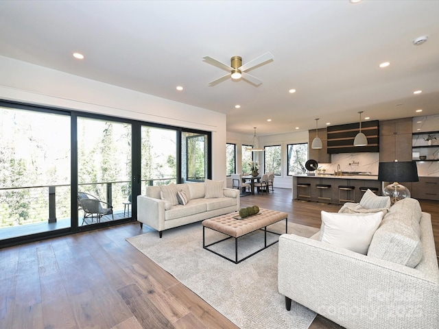 living room with sink, hardwood / wood-style flooring, and ceiling fan