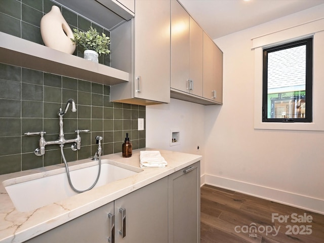 clothes washing area with sink, cabinets, hookup for a washing machine, electric dryer hookup, and dark wood-type flooring