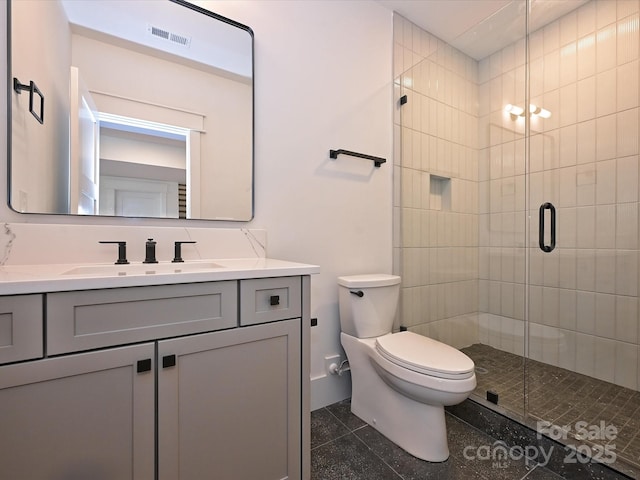 bathroom with vanity, an enclosed shower, and toilet